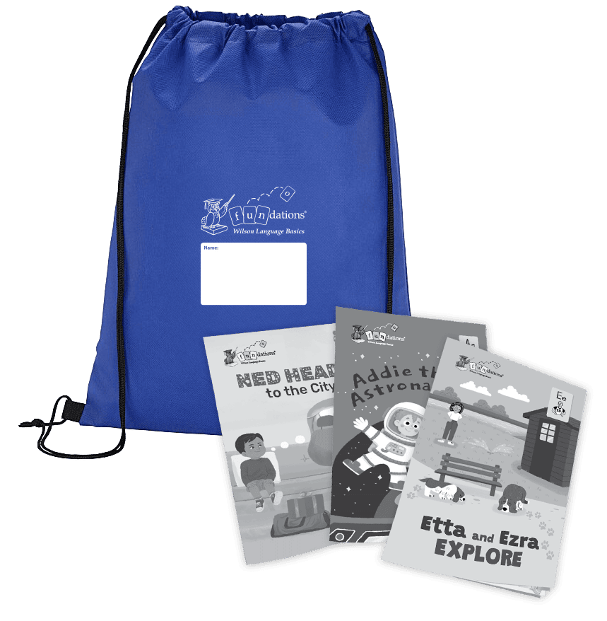 A royal blue Fundations® drawstring backpack with black cords and a white label for writing a name, shown alongside three illustrated children’s readers titled Ned Heads to the City, Addie the Astronaut, and Etta and Ezra Explore. The books are spread in front of the backpack and display black-and-white cover illustrations.