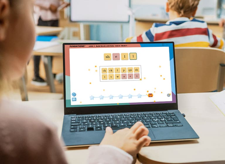 FUNHUB_Landing-Page Young student at a laptop playing a word game on FUN HUB®.